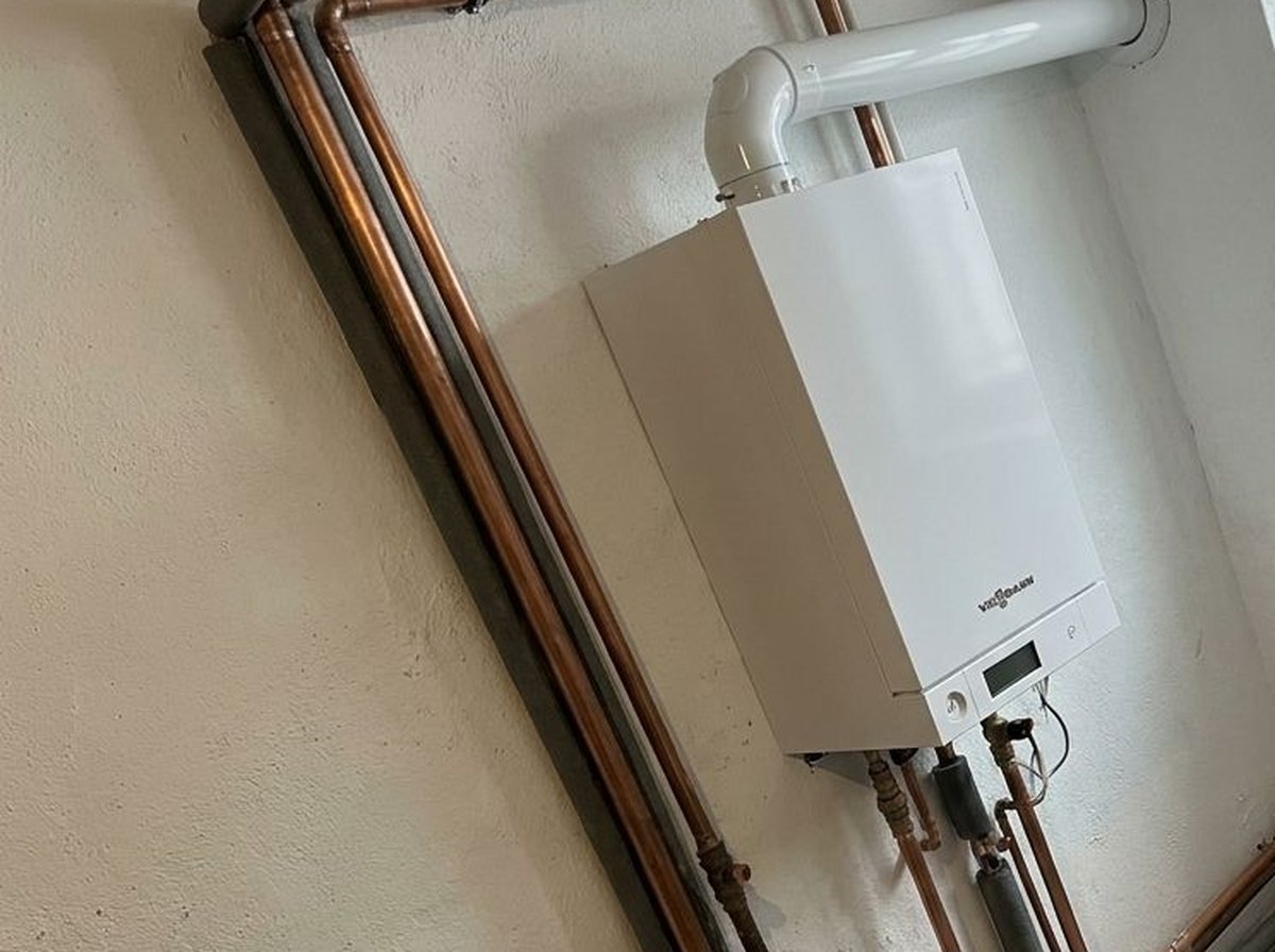 Chaudière murale Viessmann neuve avec tuyauterie cuivre dans un sous-sol repeint